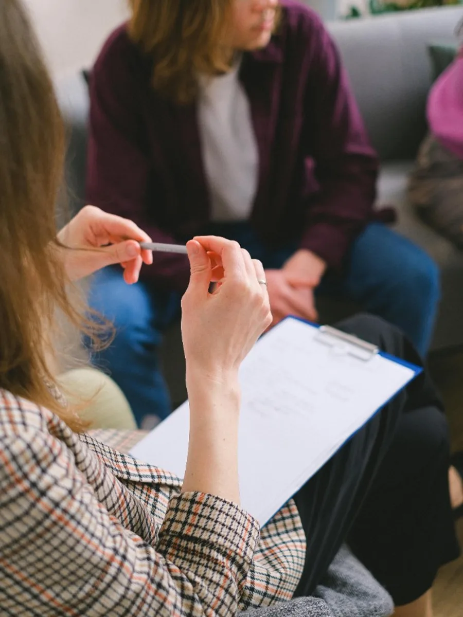 Therapist taking notes during a supportive counseling session