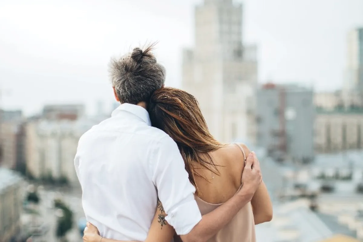 Couple embracing while looking out over the city