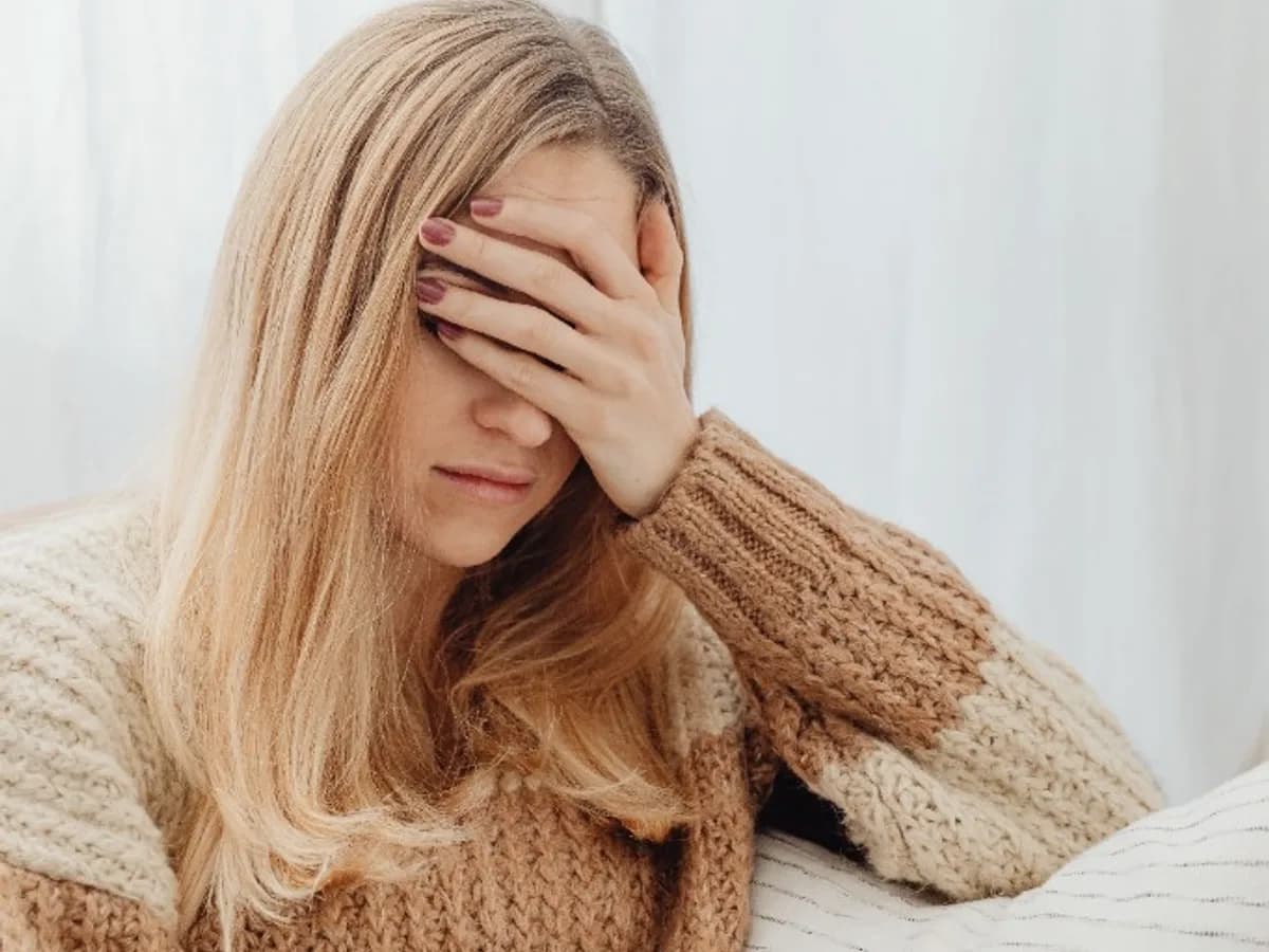 Woman holding her forehead, looking stressed
