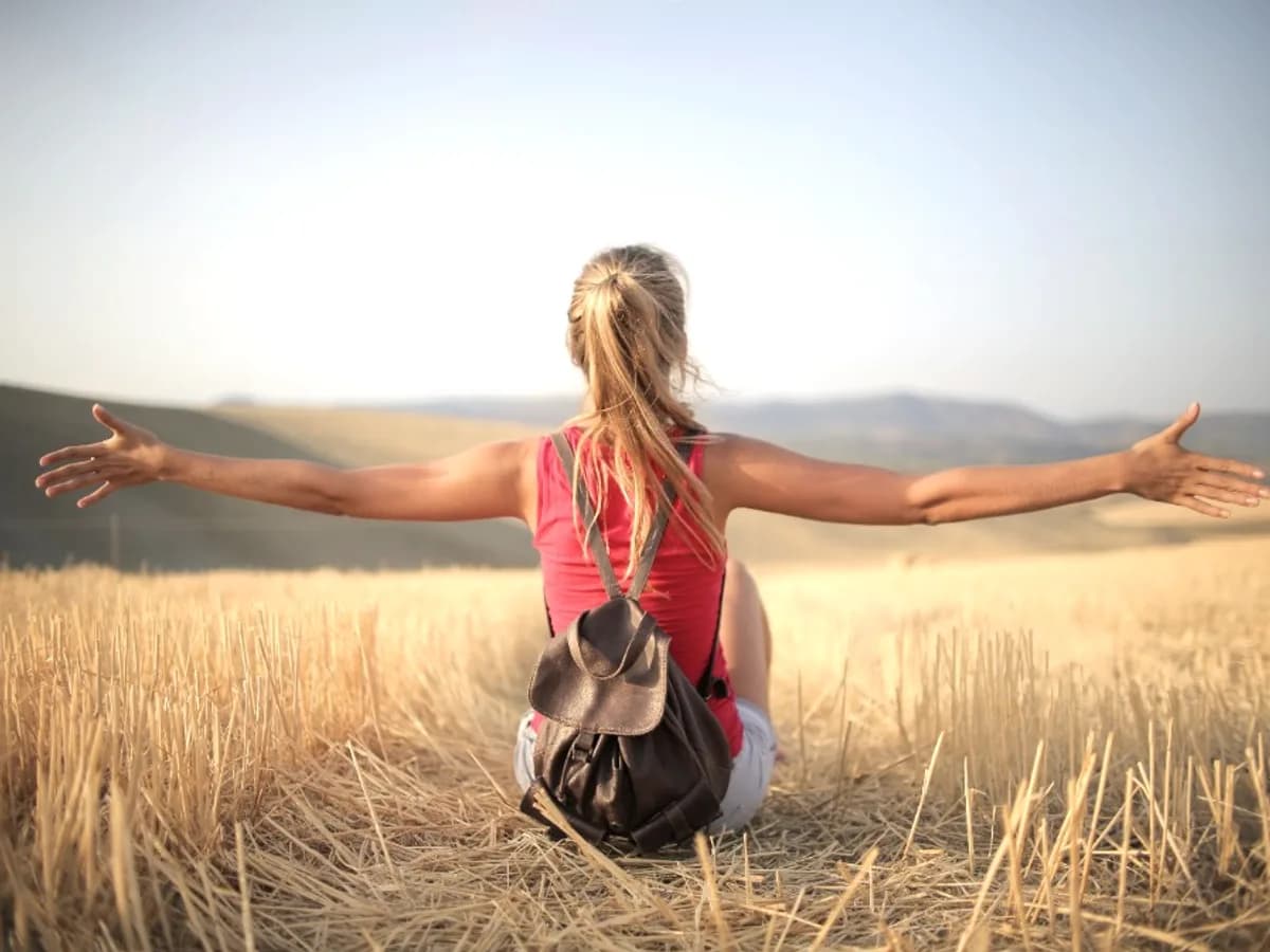 Woman with arms outstretched in an open field