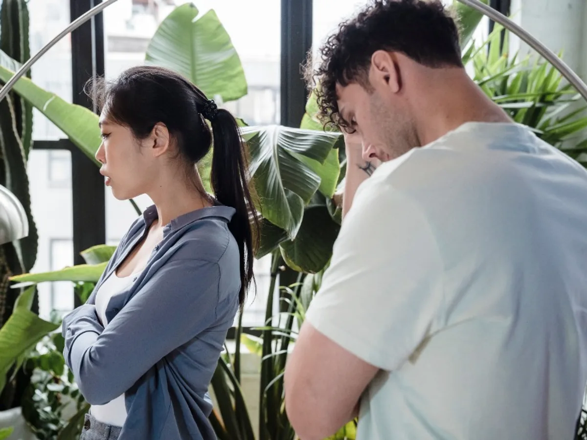 Couple standing apart with tense body language